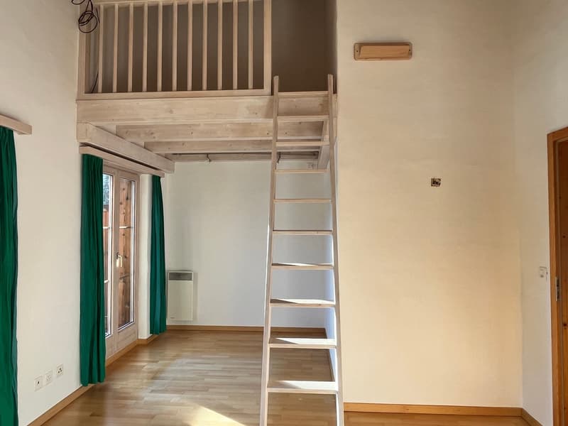 room with raised floor, wooden ladder, wooden doors, windows, curtains