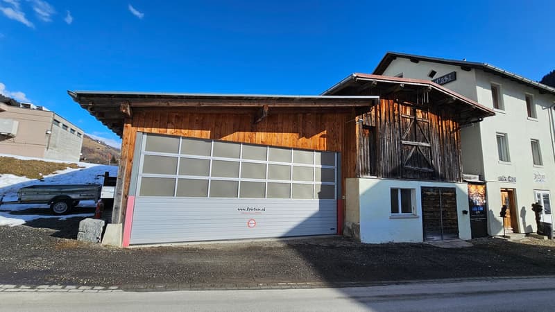 wooden building with white lower part, large garage door