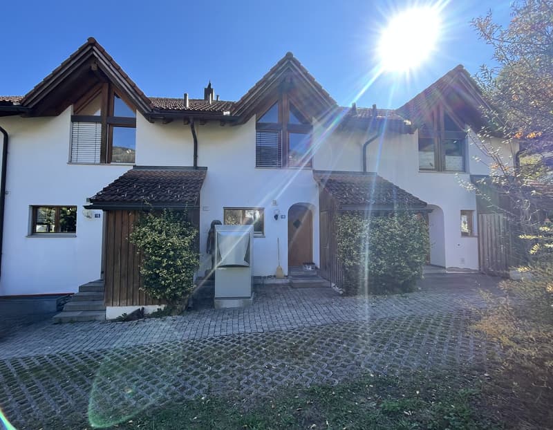 3 story house, white exterior, brown roof, large windows, brick driveway, wooden doors, plants