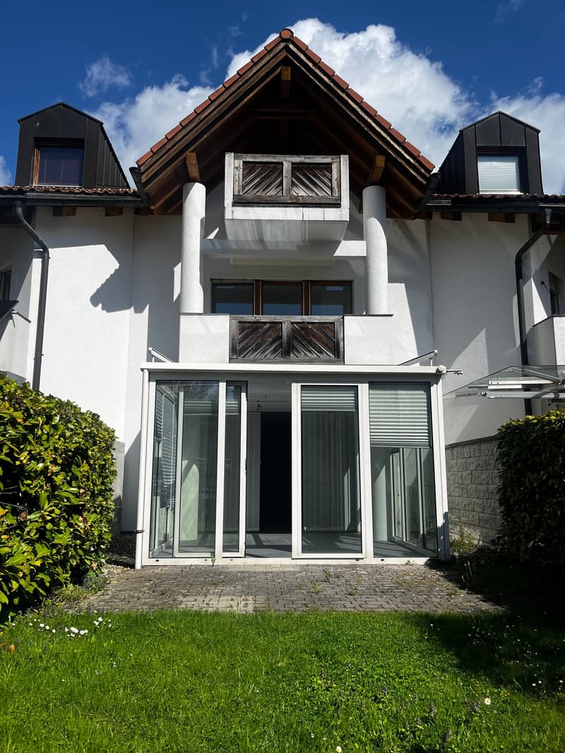 white house, brown roof, glass doors, balcony, brick pathway, green lawn