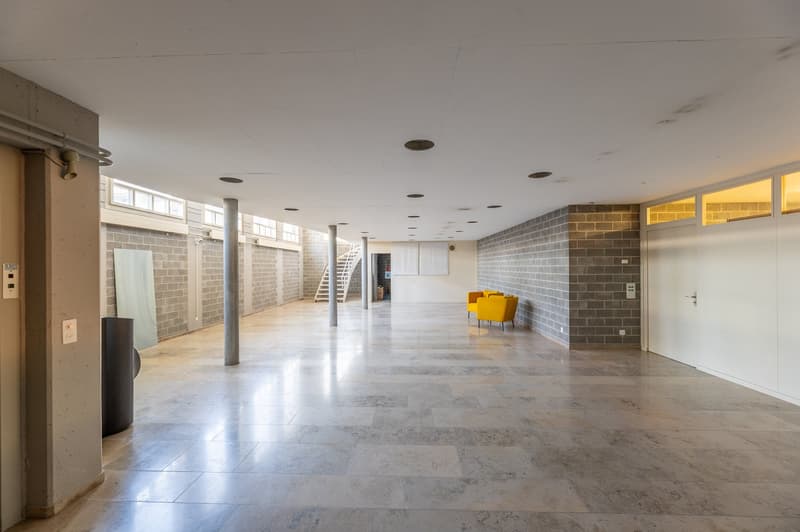 long corridor, marble floors, central pillars, two yellow armchairs