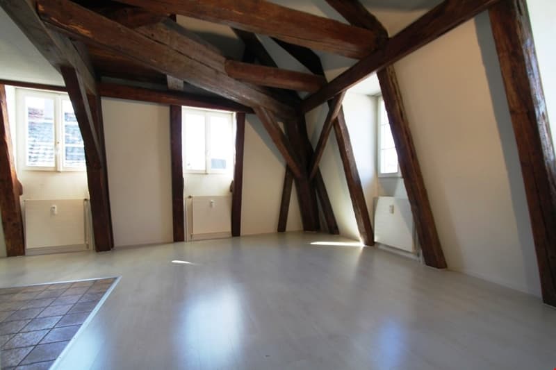 empty room, wooden beams, white walls, white floor, windows, radiators