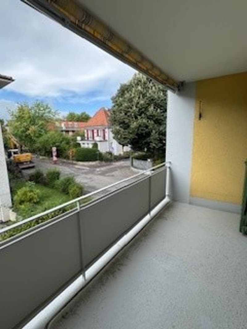 A balcony with a metal railing and a view of the road