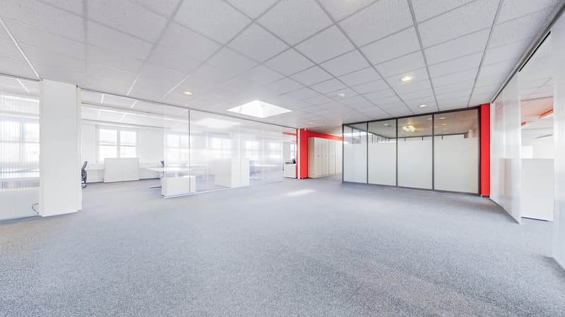 Open office space, glass walls, glass doors, gray carpet, white ceiling, white walls, red pillar, white office equipment