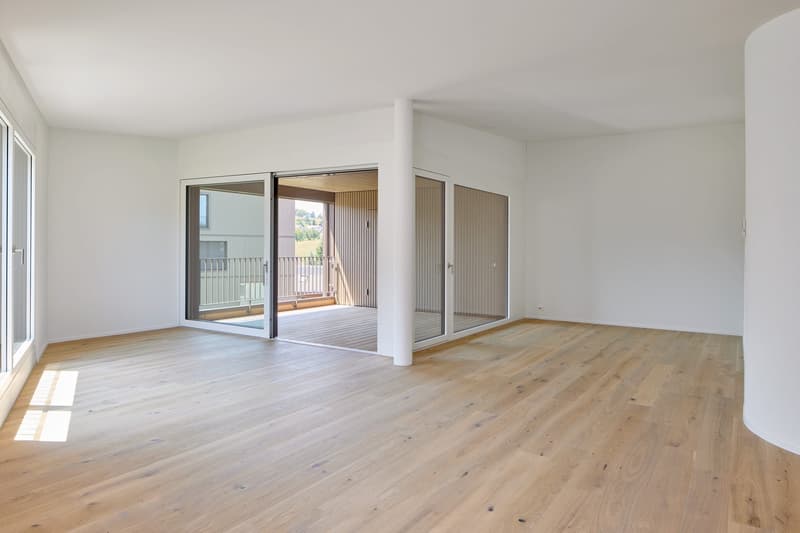 empty room, white walls, wooden floors, sliding glass doors leading to balcony