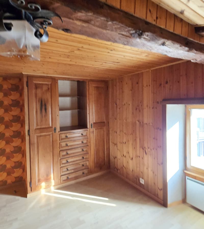 Wooden cabinets, wooden drawers, wooden paneling, window with a wooden shutter, lamp, wooden ceiling