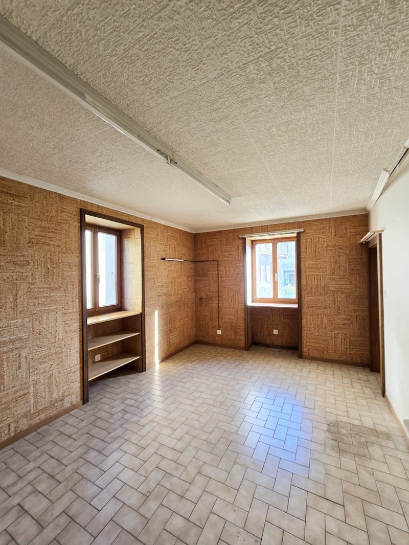 empty room with wooden walls, tile floor, two windows, one window with shelf, ceiling lights