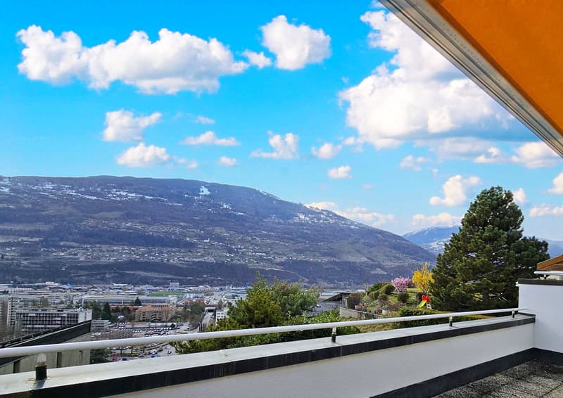 Balcony with view of city and mountains