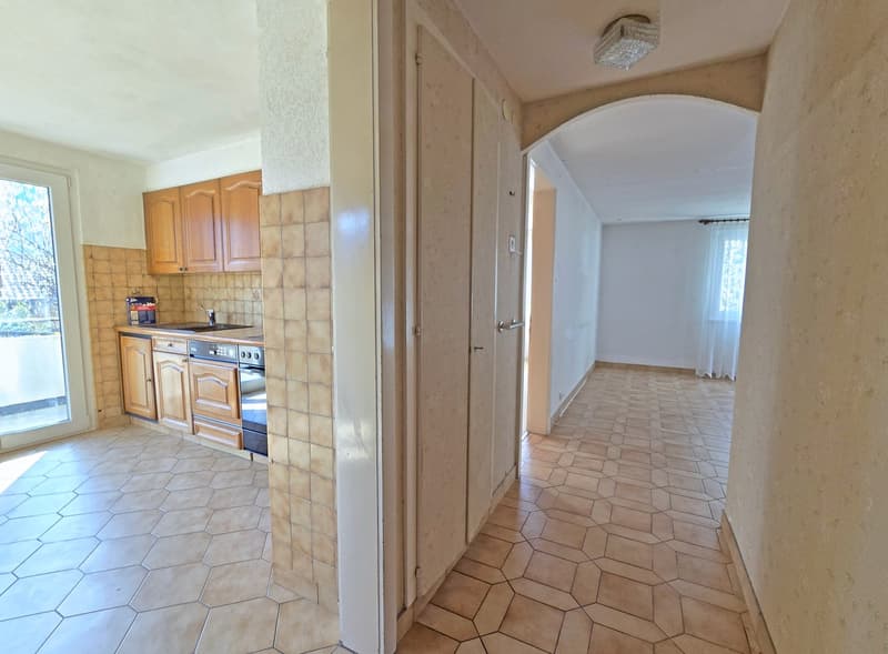 kitchen with wooden cabinets, tiled floor, sink, oven, balcony with glass door