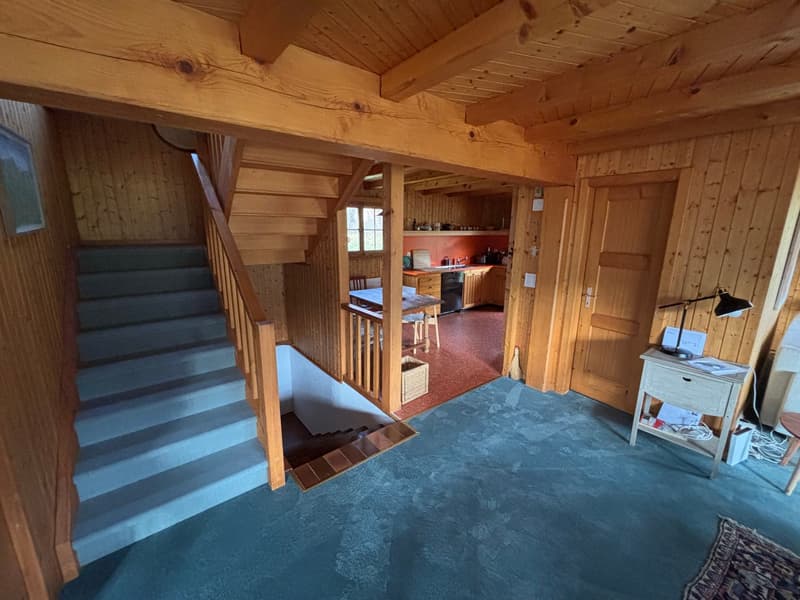 wooden staircase, wooden beams, kitchen area with dining table, blue carpet