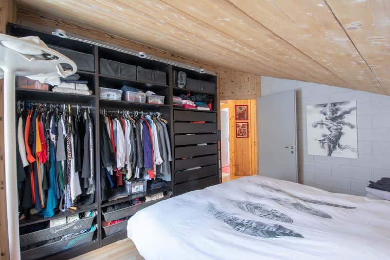 bedroom with a large wardrobe, double bed, ceiling spotlights, wooden walls, picture on the wall