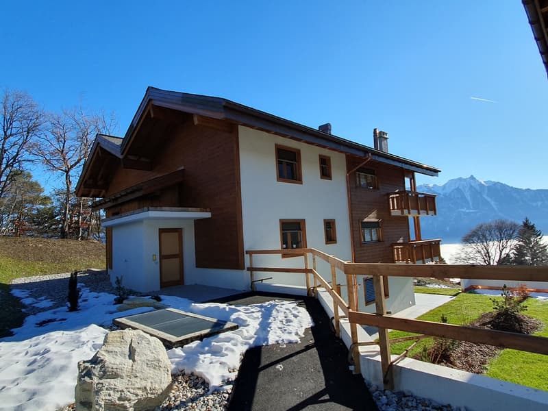 two story house, brown wooden facade, white walls, multiple balconies, mountain view