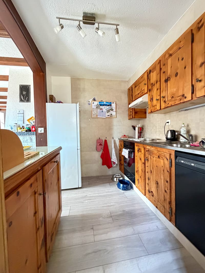 kitchen with wooden cabinets, white refrigerator, dishwasher, tiled floor, ceiling lights, sink, stove, and various kitchen items