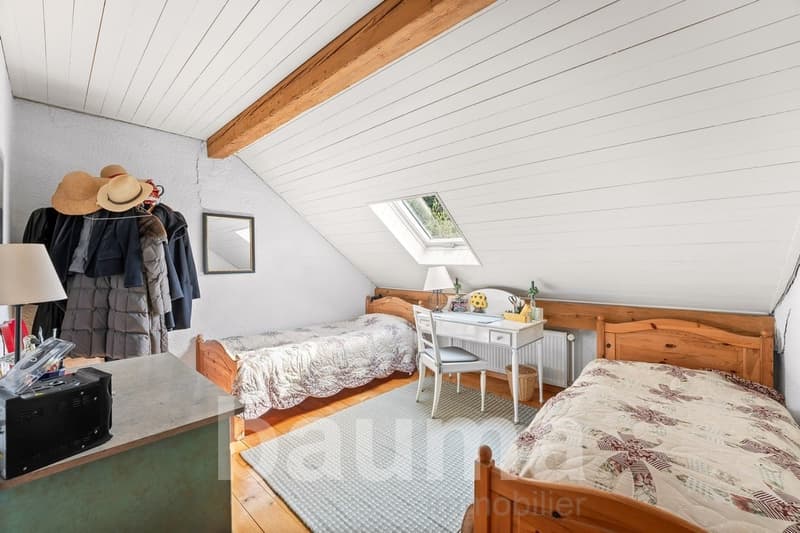 bedroom with two wooden beds, desk, chair, mirror, and a shelf with various items