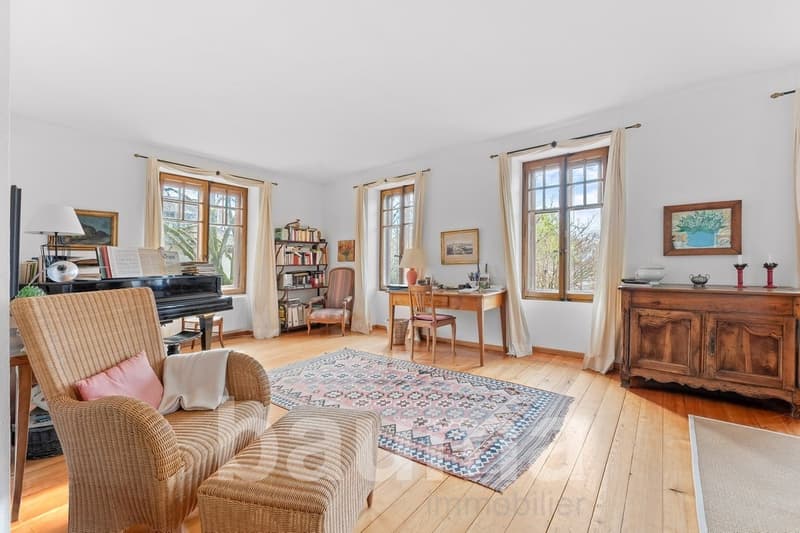 large window with view, piano, bookshelves, chairs, desk, rug, lamp