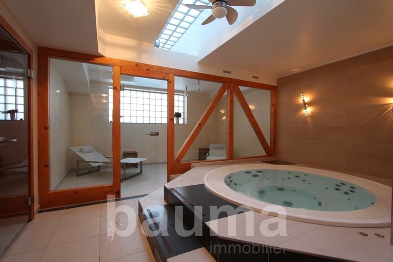 Large bathroom with a jacuzzi tub, wooden beams, and a fireplace