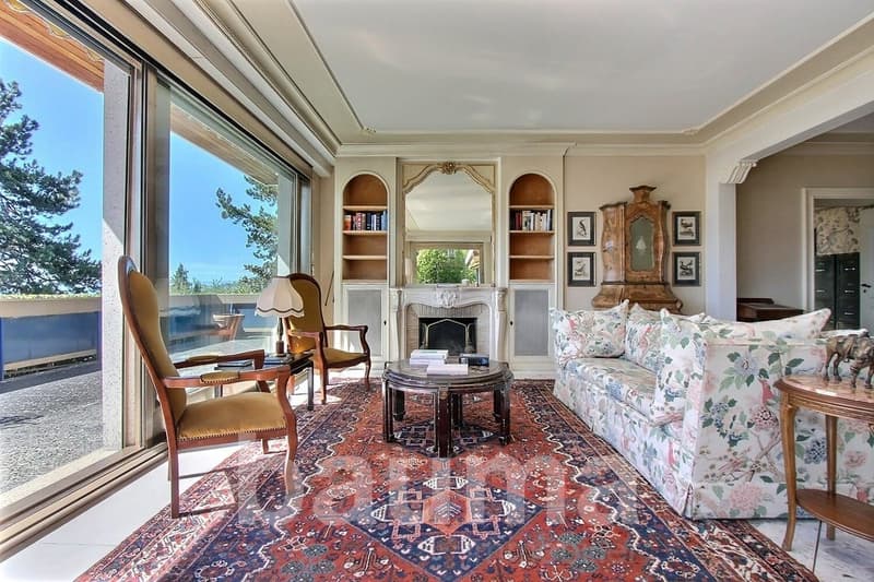 large windows, fireplace, bookshelves, couch, coffee table, chairs, rug, side table, sculpture
