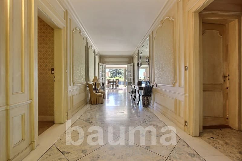 marble floor, white walls, large windows, hallway leading to the living room, table with lamp, chairs, umbrella stand