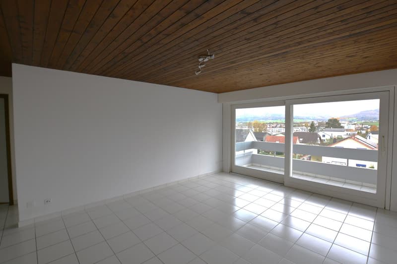 tiled floor, white walls, sliding glass doors leading to balcony
