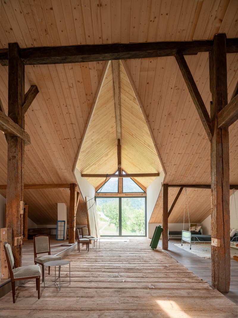 wooden beams, wooden floor, glass windows, a few chairs and a table, a swing