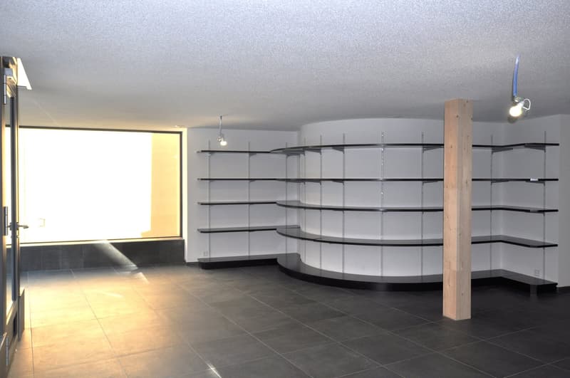 empty room, black tile flooring, modern shelving with glass panels, recessed ceiling lights, large glass window on one wall