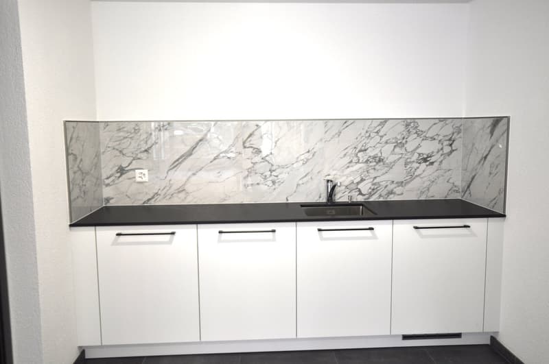 modern kitchen with white cabinets, black marble countertop, stainless steel sink, faucet, power outlet
