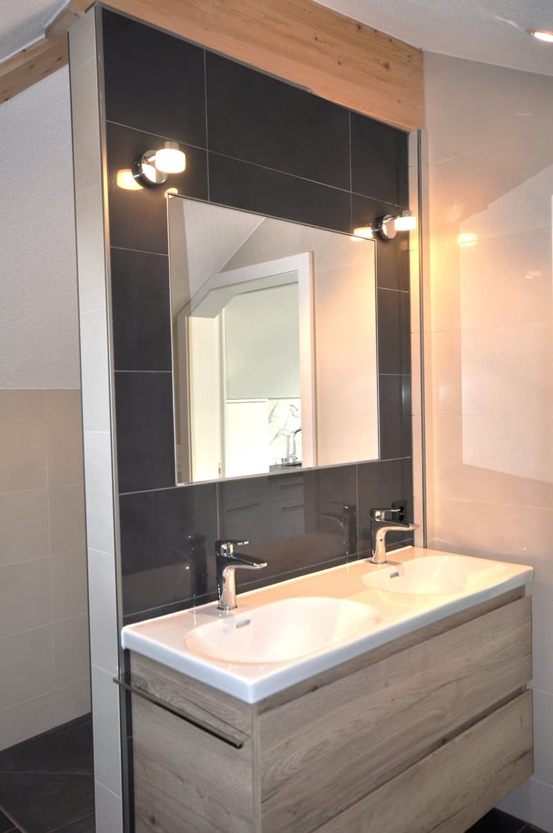 double sink, large mirror, modern fixtures, tiled walls, walk-in shower