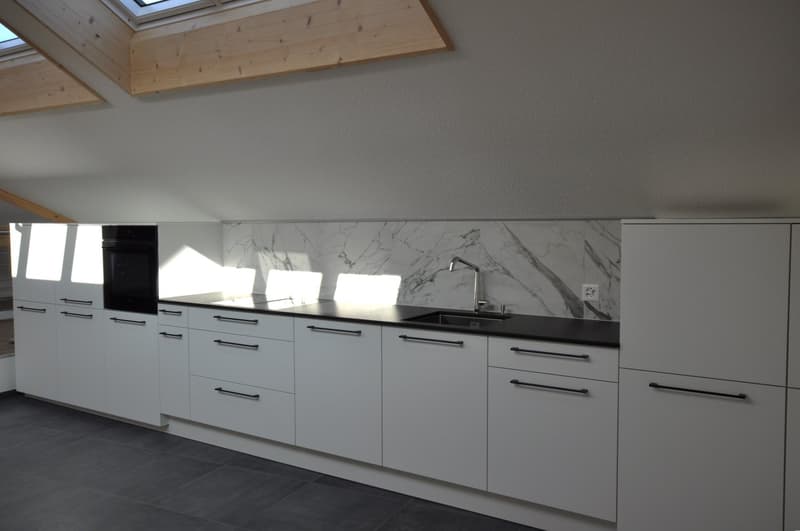 modern kitchen with marble backsplash, white cabinets, black countertops, built-in oven and stove