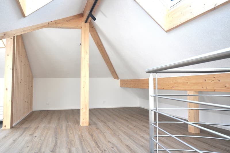 Wooden attic room, wooden beams, white walls, wooden floors
