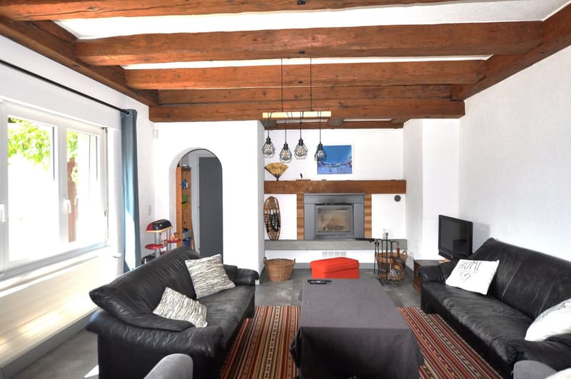 black leather couches, fireplace, large windows, shelves, ottoman