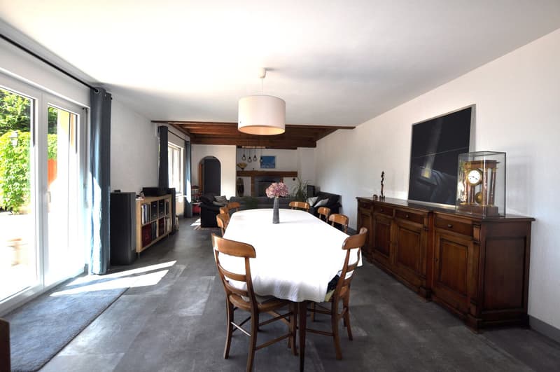 Dining room, long table, wooden chairs, white tablecloth, wooden cabinet, painting, chandelier