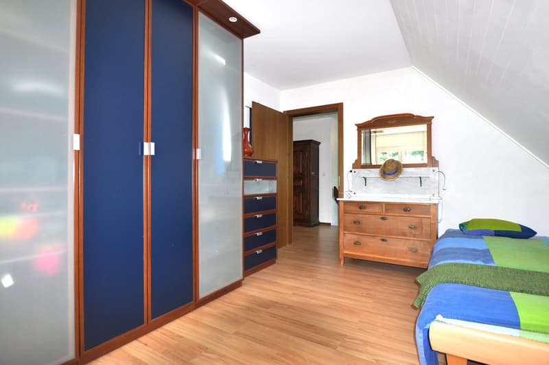 bedroom with wardrobe, wooden floor, wooden bed, wooden chest of drawers, mirror