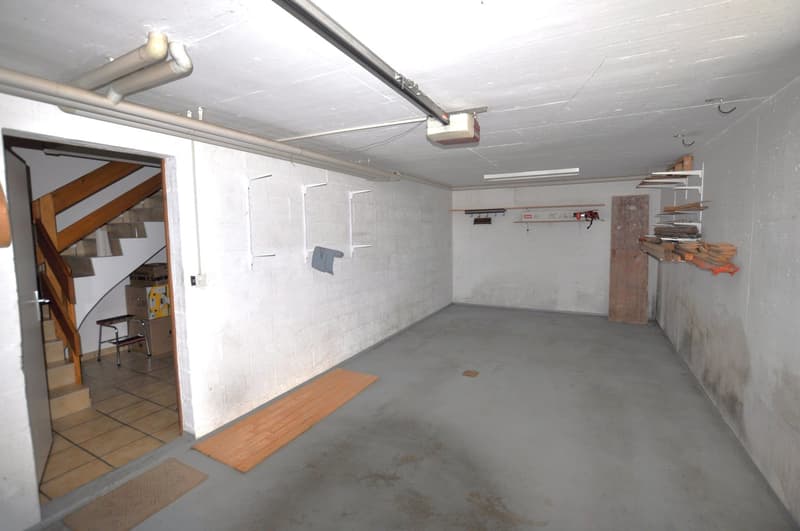 Empty storage room with wooden planks, a stepladder, and storage boxes