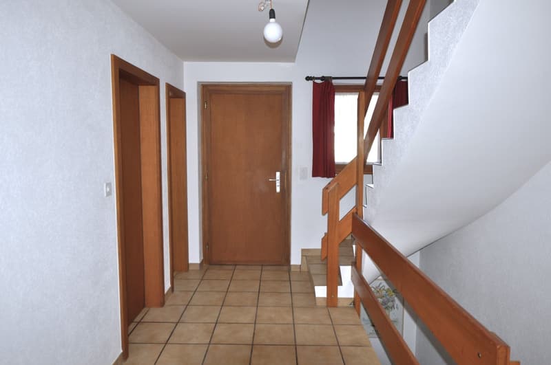 empty hallway with white and brown wooden door, red curtain, white wall, wooden staircase