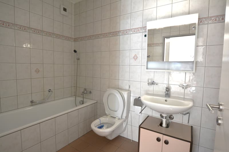 white tiles, bathtub, toilet, sink, mirror, shower head