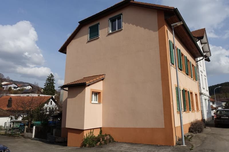 3 story house, beige and brown exterior, green shutters, brown roof, street view