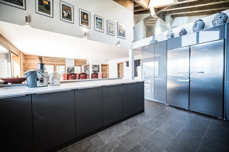 modern kitchen with stainless steel appliances, granite countertop, wooden cabinets, artwork on the wall