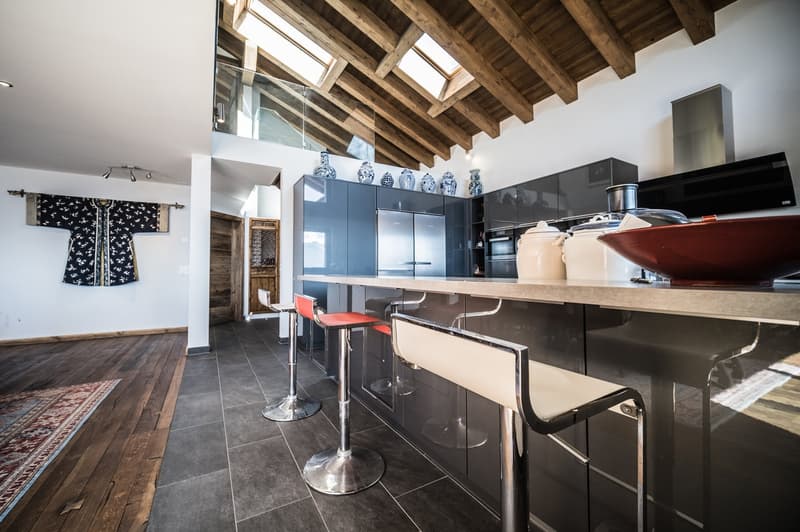 Contemporary open-plan kitchen, raised ground floor, central island, stainless steel appliances, wooden ceiling, natural light from skylights, contemporary design, wooden flooring, white walls, sleek cabinetry