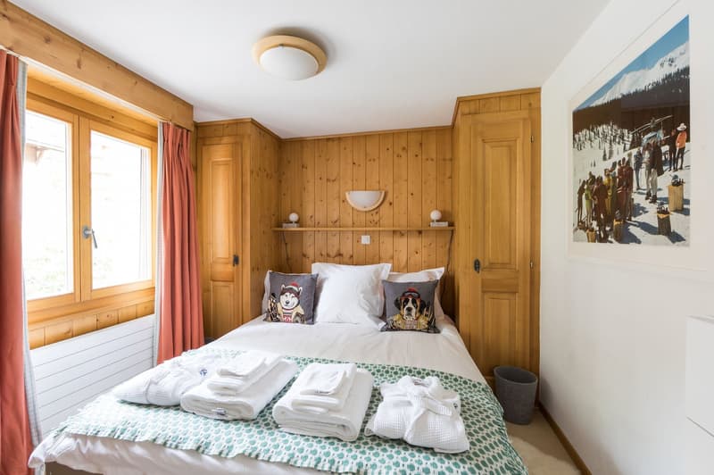 wood paneling, queen size bed, white bedsheets, two nightstands, radiator