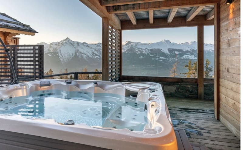 outdoor hot tub on a wooden deck, mountain view, wooden wall, glass fencing