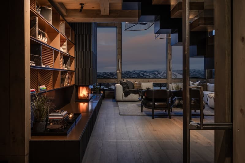 Wooden flooring, open layout, large window, fireplace, modern furniture, scenic view