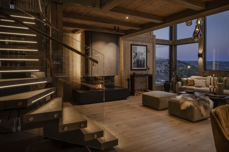 modern fireplace, wooden staircase, wooden floor, large glass windows, sofa, coffee table, picture frame