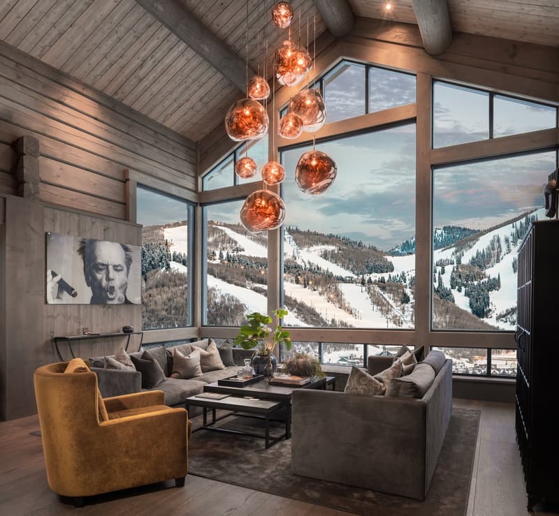 large windows, wooden ceiling, beige couch, black center table, wood floor
