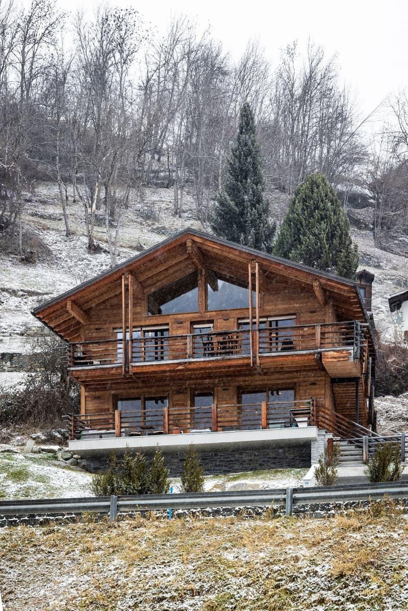 wooden chalet, 2 stories, balcony, large windows, snow covered ground