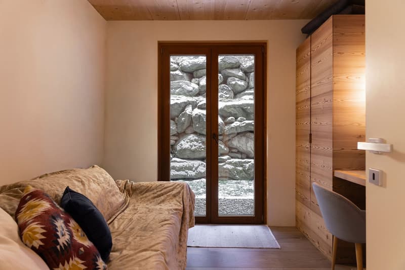 sofa, pillows, rug, wooden door, wooden cabinet, chair, desk, wall switch