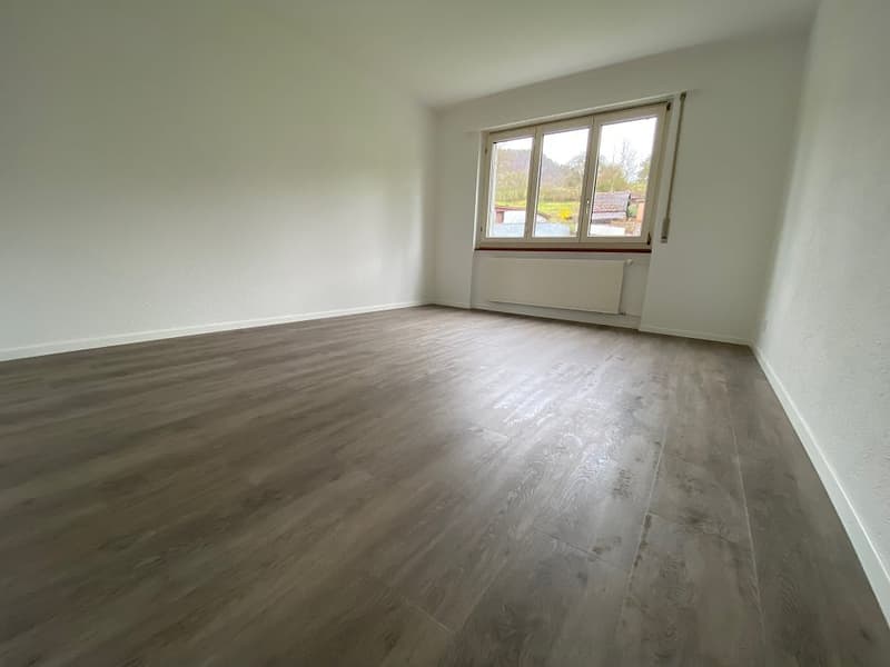 Spacious room with white walls, large windows, and hardwood-style flooring. The room appears to be empty, ready for furnishing and decorating.