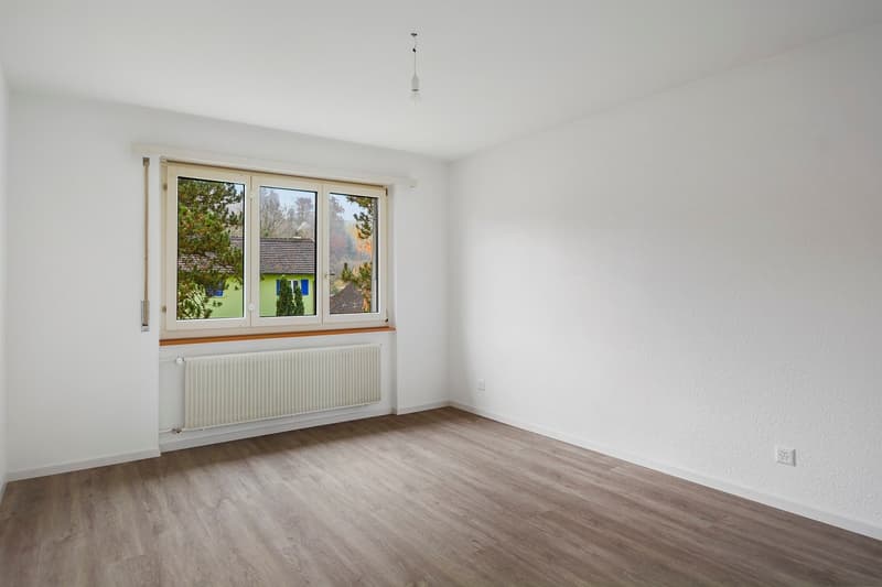 white painted walls, wooden flooring, white radiator, windows
