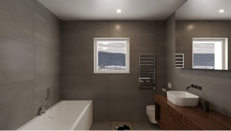 Spacious bathroom with tub, sink, toilet, wooden cabinet, window with view