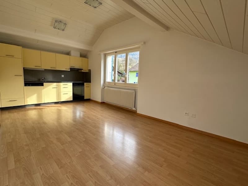 empty kitchen with wooden floor, yellow cabinets, white walls, window, radiator