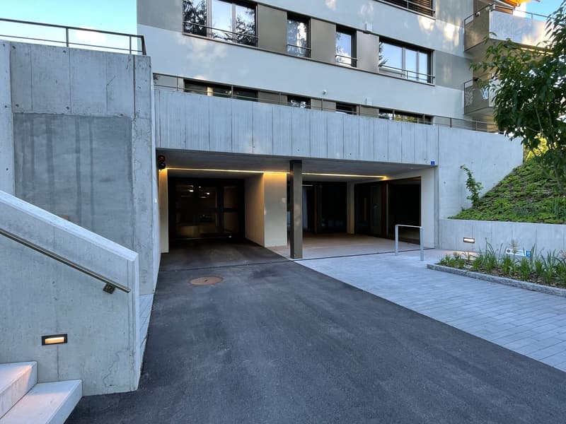 Apartment building entrance with covered parking spaces